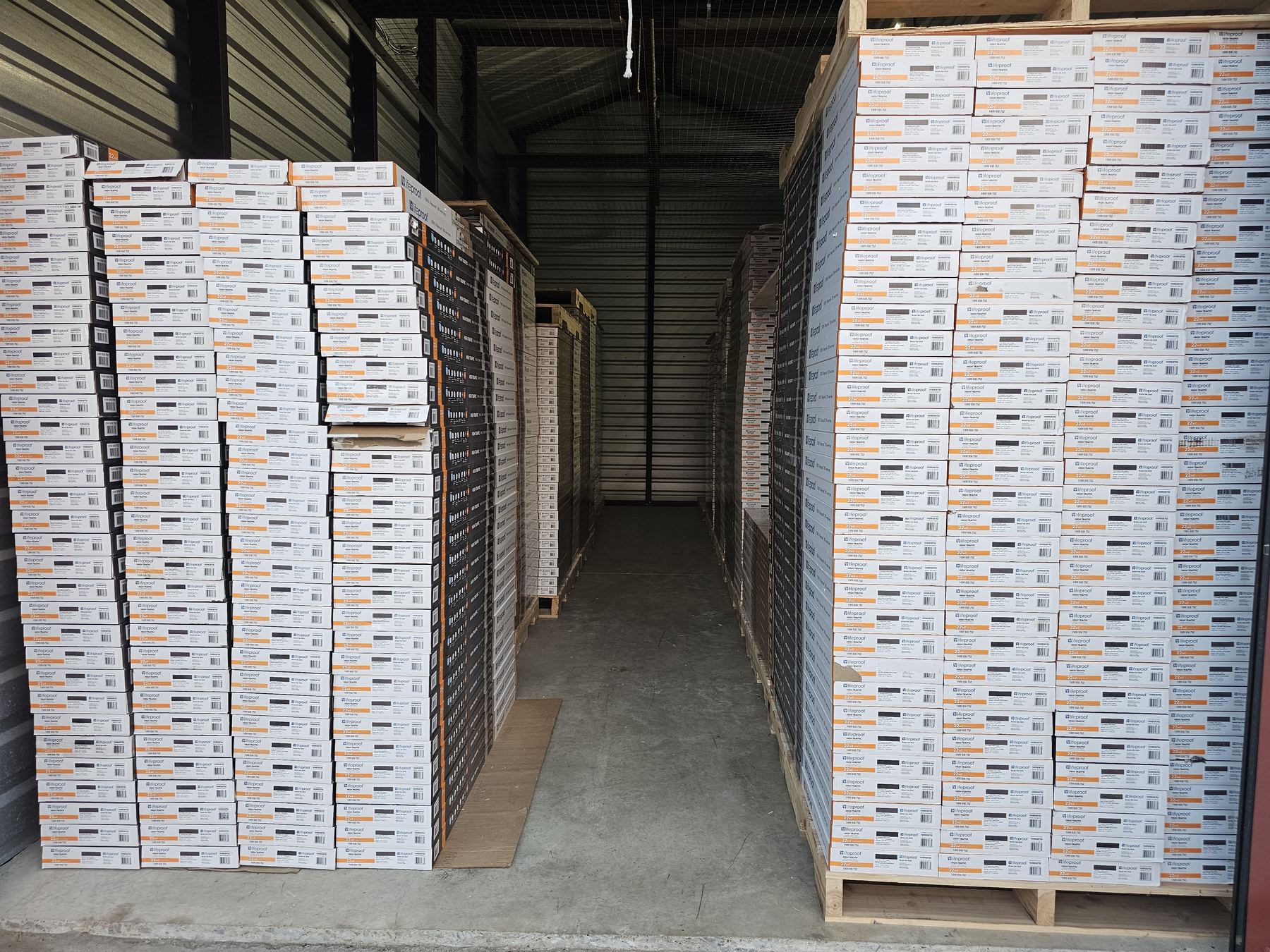 Pallets of flooring boxes stacked in the Invicta Home Supply warehouse